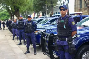 Guardas municipais de Teresina em pé diante de seus veículos.