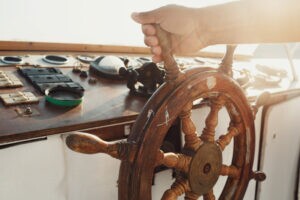 aprendiz da marinha eam girando roda de madeira do navio em dia ensolarado