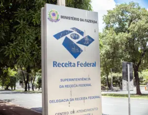 placa de ferro escrito superintendência da receita federal e delegacia da receita federal com rua e floresta no fundo