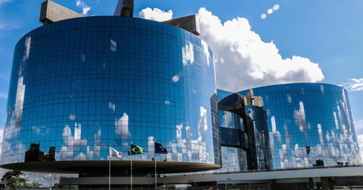 Prédio espelhado do Ministério Público da União sob um céu azul, refletindo a luz