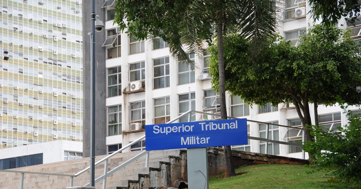 Fachada de um prédio com uma placa "Superior Tribunal Militar" com árvores em frente / Concurso STM