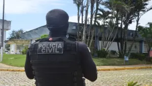 Imagem de um policial fardado de costas olhando para a fachada sede da corporação - Concurso PC RS