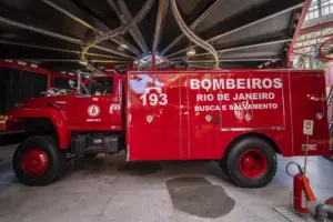 Caminhão de bombeiros vermelho parado em um edifício, localizado no Rio de Janeiro.