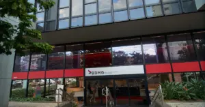 Fachada do prédio do banco BDMG, destacando um letreiro vermelho e branco.