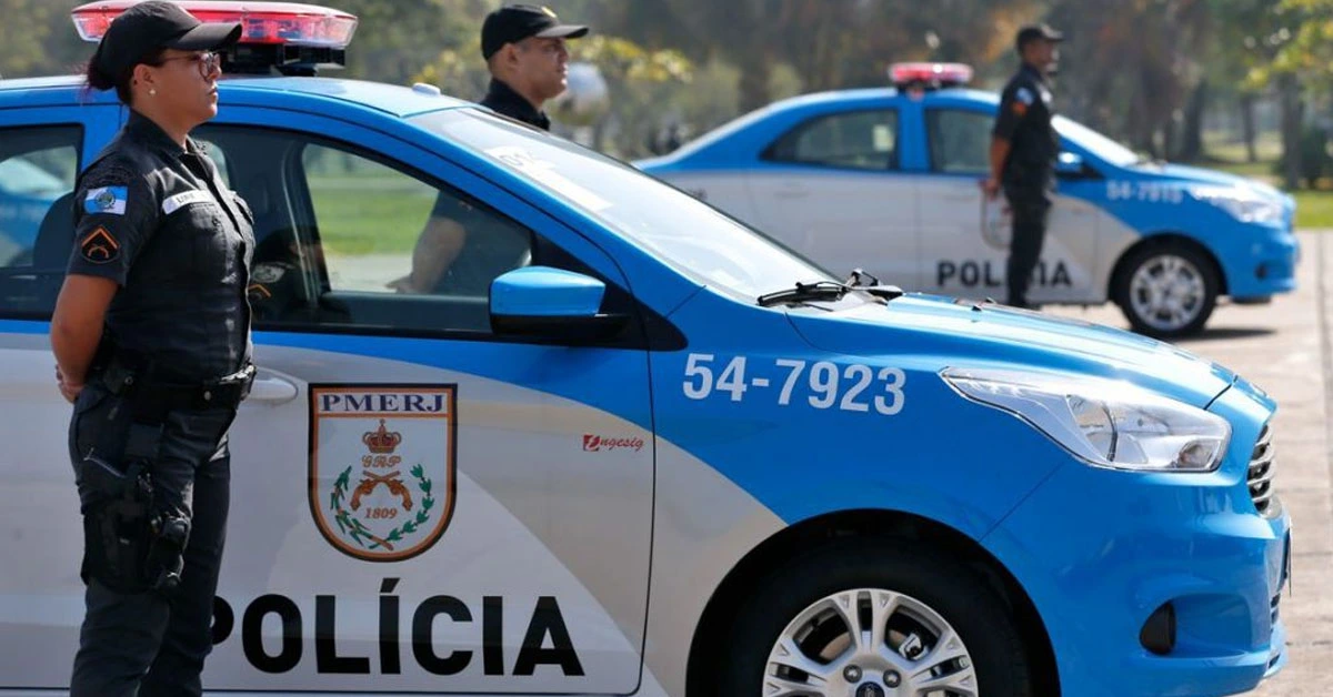 Policiais ao lado de uma viatura policial azul e branca / Concurso PMERJ