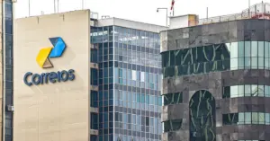 Fachada de um prédio de uma agência dos correios com grande logo do órgão / Concurso Correios