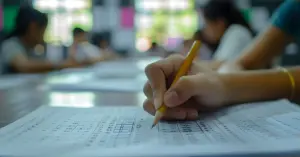 Estudante concentrado fazendo prova com lápis e folha de respostas, demonstrando foco / Concurso Nacional Unificado