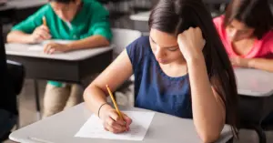 Grupo de estudantes do ensino médio fazendo prova em sala de aula / CNU