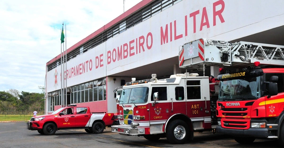 Caminhão vermelho do Corpo de Bombeiros Militar DF, com escada, no topo estacionado em frente ao batalhão.