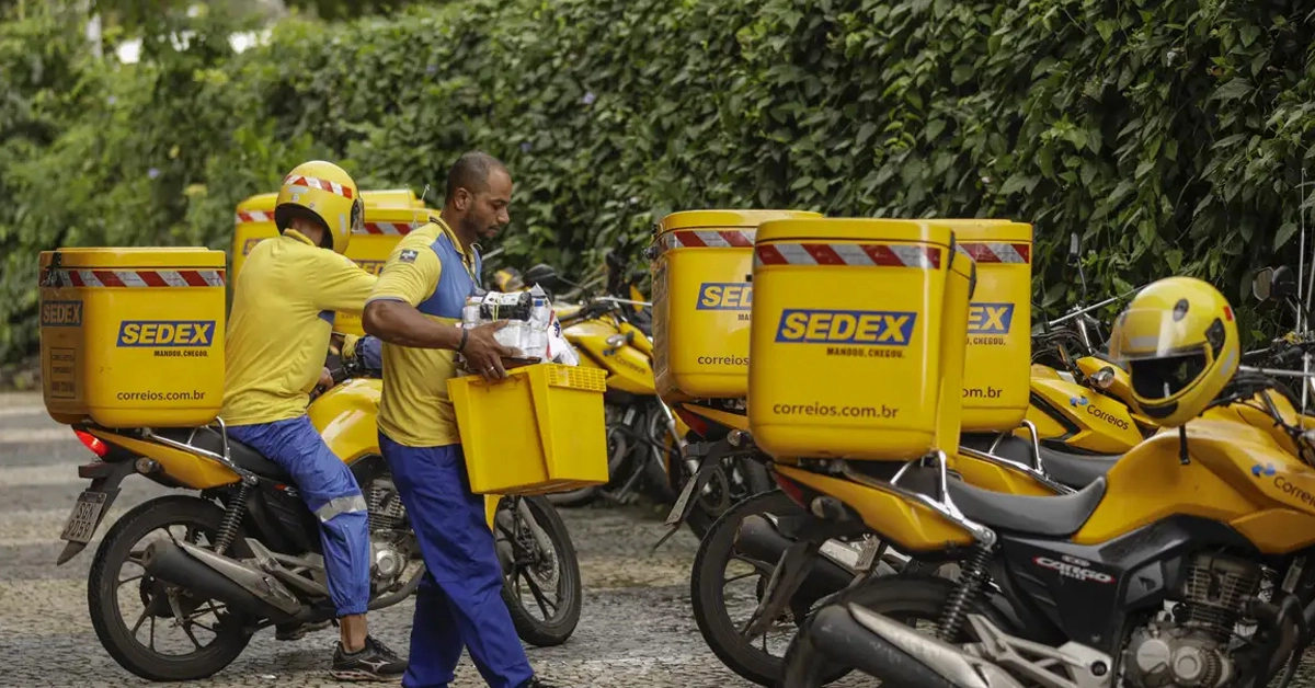 carteiro dos correios levando encomenda para moto