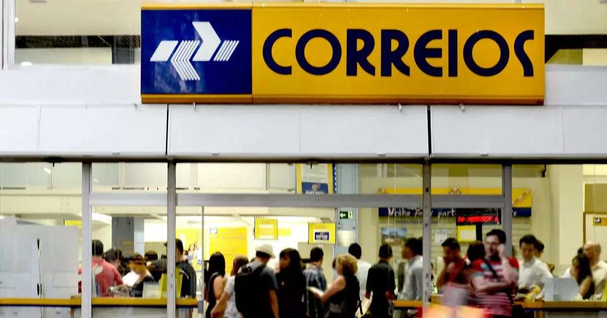 Fachada de uma das agências dos Correios com diversas pessoas dentro