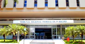 Fachada de um edifício institucional com a placa acima da entrada principal do Tribunal Regional Federal da 1° Região / TRF1