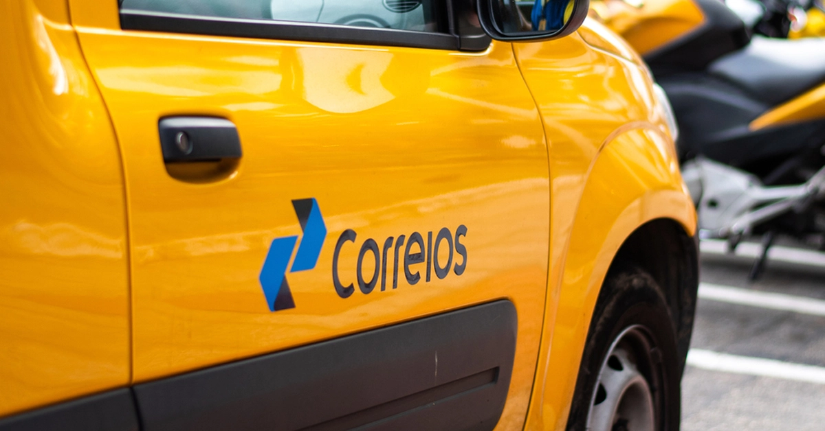 visão lateral de carro amarelo com a logo dos correios