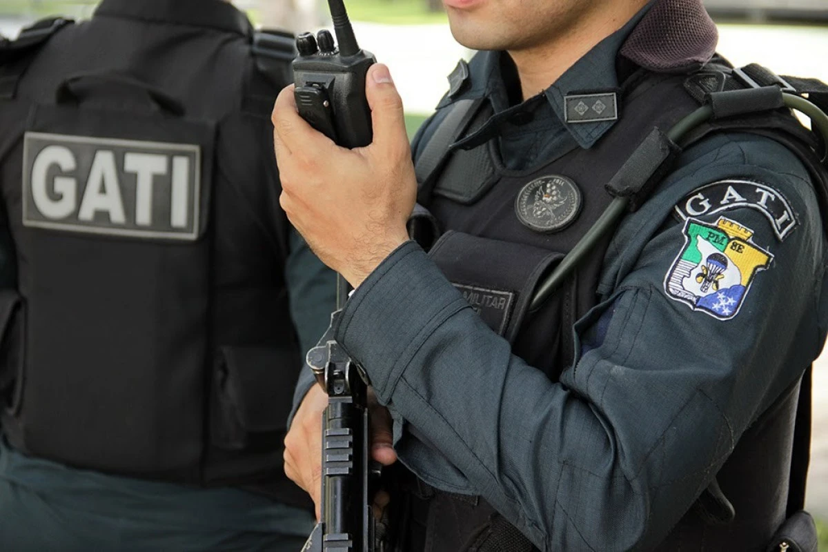 homem com uniforme da pm se segurando telefone