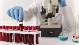 imagem de um profissional de laboratório realizando análise de sangue utilizando microscópio - Concurso Hemominas