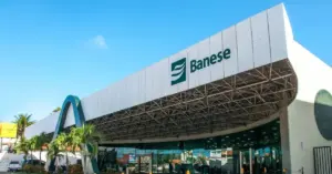 Fachada do Banese em um dia ensolarado com pequena área verde em frente / Concurso Banese