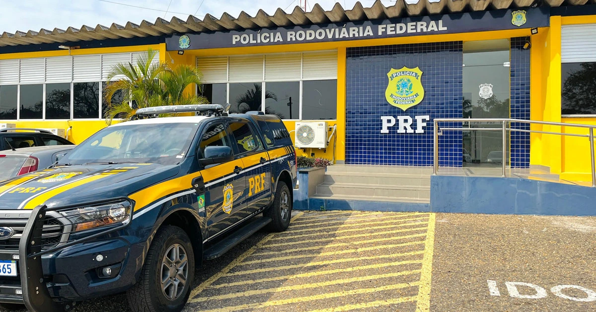 Entrada da Polícia Rodoviária Federal em um dia ensolarado e com uma viatura policial estacionada na frente / Concurso PRF