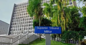 Fachada de um prédio com uma placa "Superior Tribunal Militar" com árvores em frente / Concurso STM