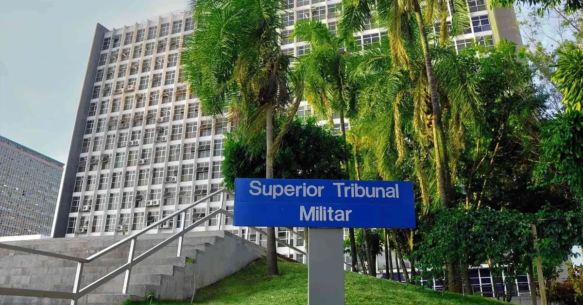 Fachada de um prédio com uma placa "Superior Tribunal Militar" com árvores em frente / Concurso STM