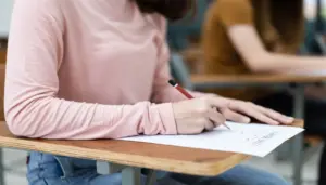 imagem de uma mulher em sala de aula realizando um teste - Concurso CGE PI