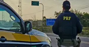 Polícial Rodoviário Federal em frente ao carro / Concurso PRF