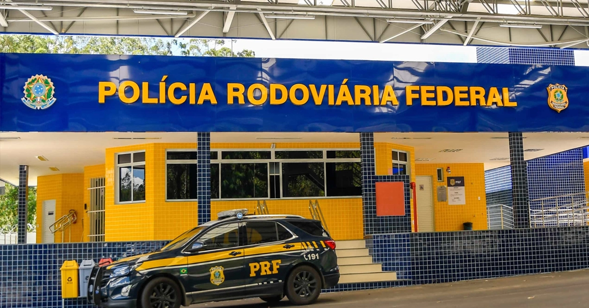 Entrada da Polícia Rodoviária Federal em um dia ensolarado e com uma viatura policial estacionada na frente / Concurso PRF