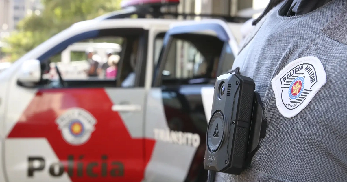 Viatura da Polícia Militar de São Paulo estacionado na rua e unifome policial em primeiro plano / Concurso PM SP