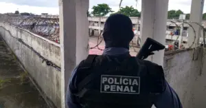 Agente penitenciário da Polícia Penal ES em pé na entrada do presídio, na guarita / Concurso Polícia Penal ES