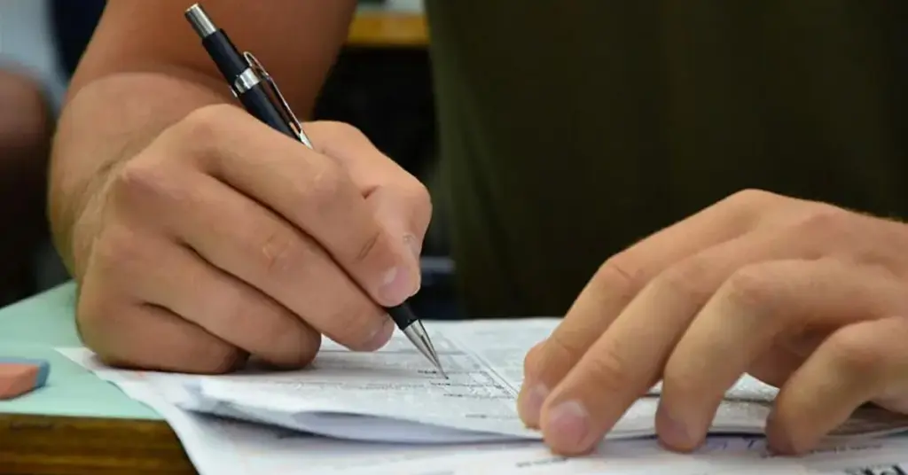 Estudante escrevendo em papel / Concurso Prefeitura de Tremembé.