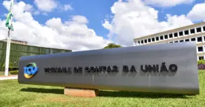 Fachada do Tribunal de Contas da União (TCU) em Brasília, com um grande letreiro metálico cinza / Concurso TCU