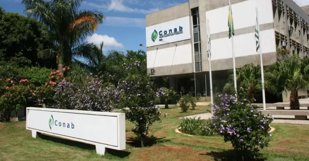 Fachada do prédio da Conab com bandeiras hasteadas e letreiro em frente / Concurso Conab