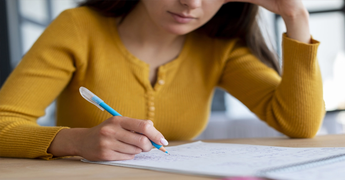 Estudante sentado escrevendo em papel / Concurso MPU