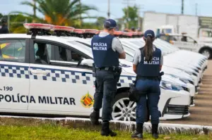 Aprovados no concurso PM DF do lado de suas viaturas.