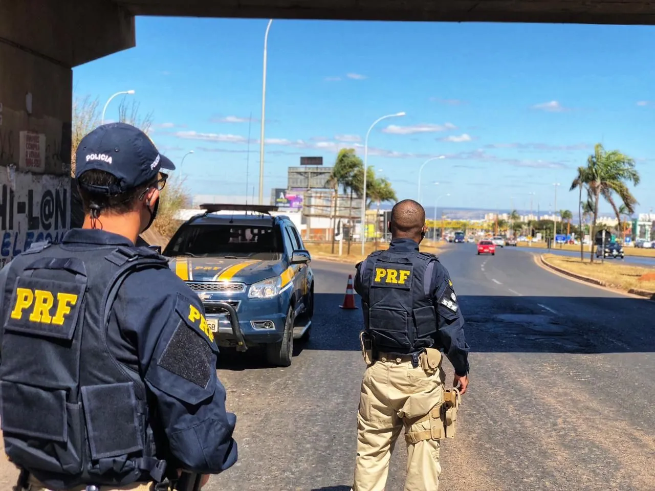 Aprovados no concurso PRF trabalhando em uma rodovia.