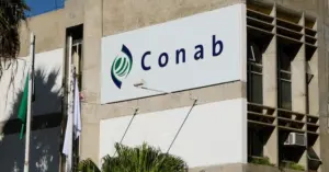 Fachada do prédio da Conab com bandeiras hasteadas e letreiro em frente / Concurso Conab