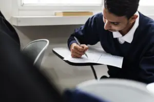 Homem preenchendo a prova de um concurso